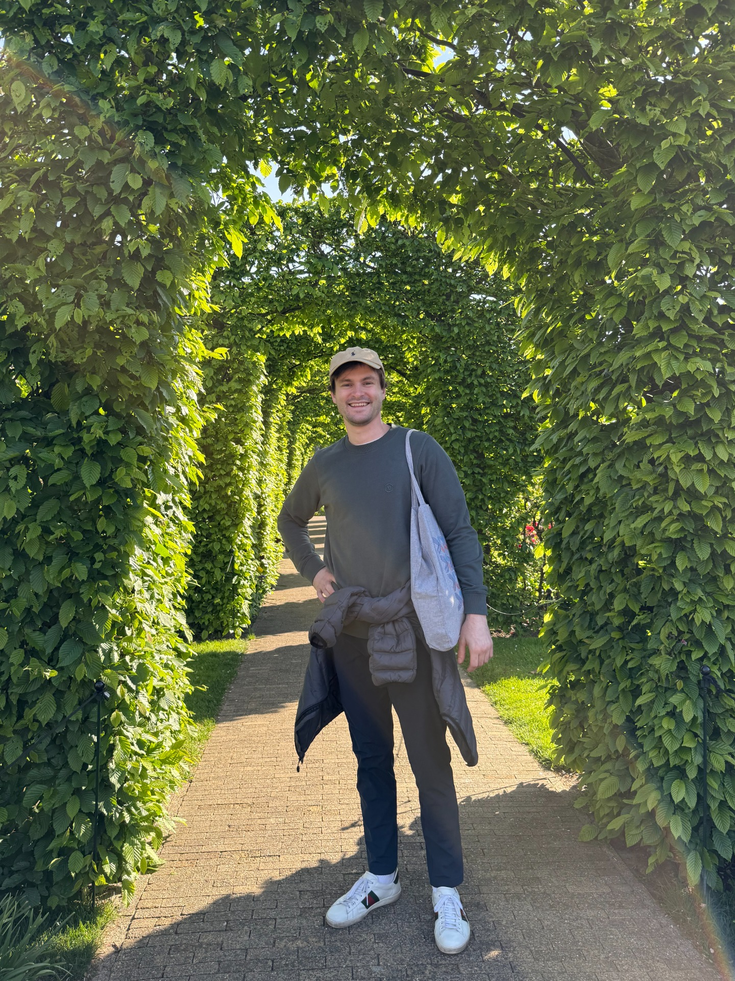 Nate Scott standing under a leafy garden archway